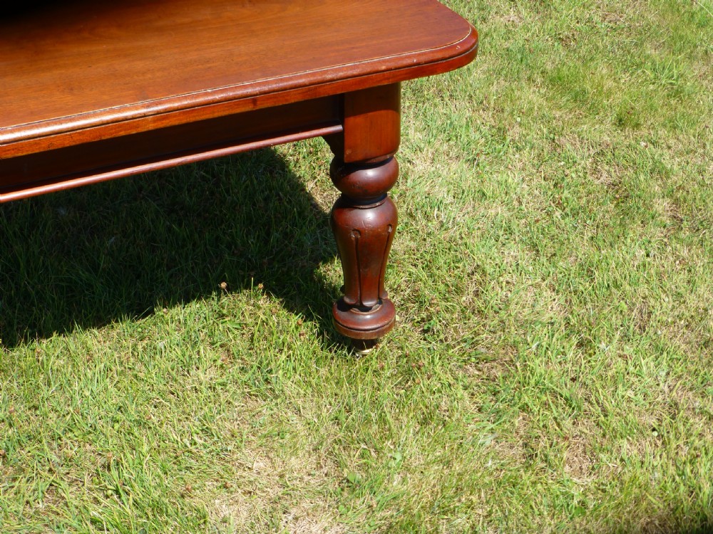 A large Regency extending mahogany dining table featuring a polished rectangular top, three extension leaves, and turned wood legs. View IX