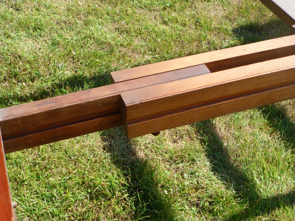 A large mahogany wind-out extending dining table featuring turned legs fitted with brass castors and rounded top corners. View VII