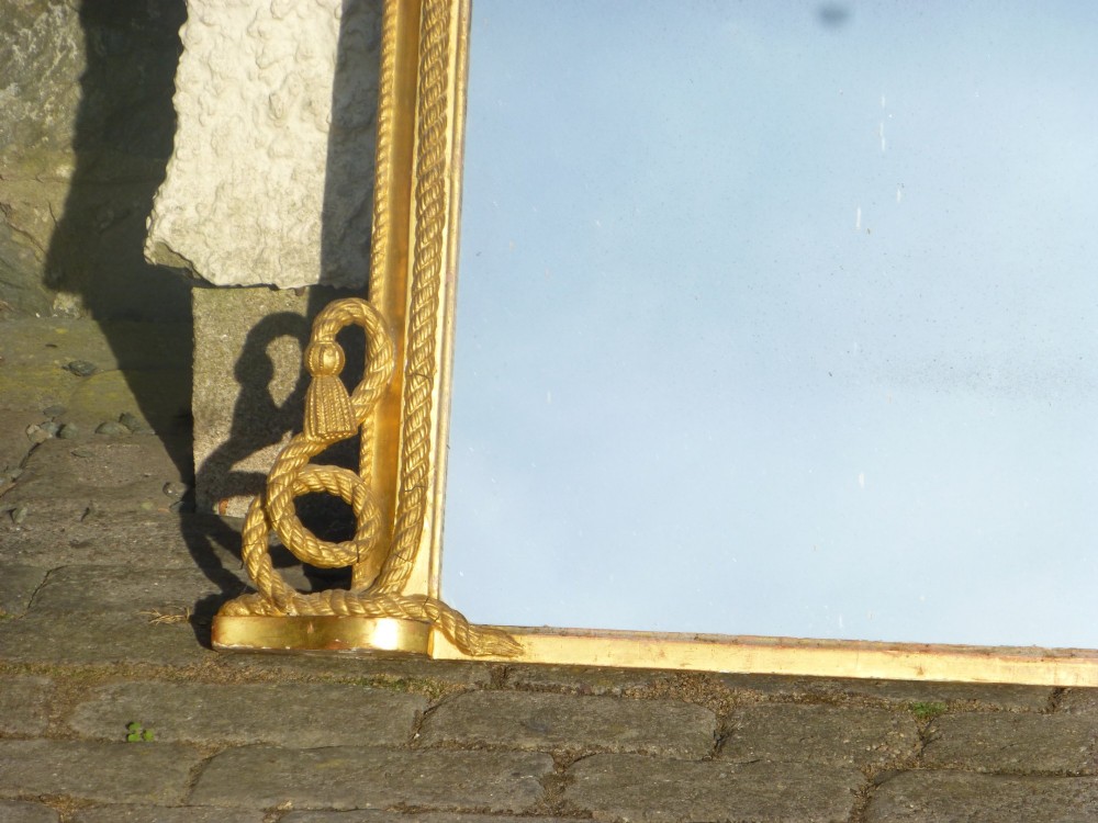 An arched antique giltwood overmantel mirror featuring a carved rope twist frame with tied knot cresting and scroll details at the base. View II