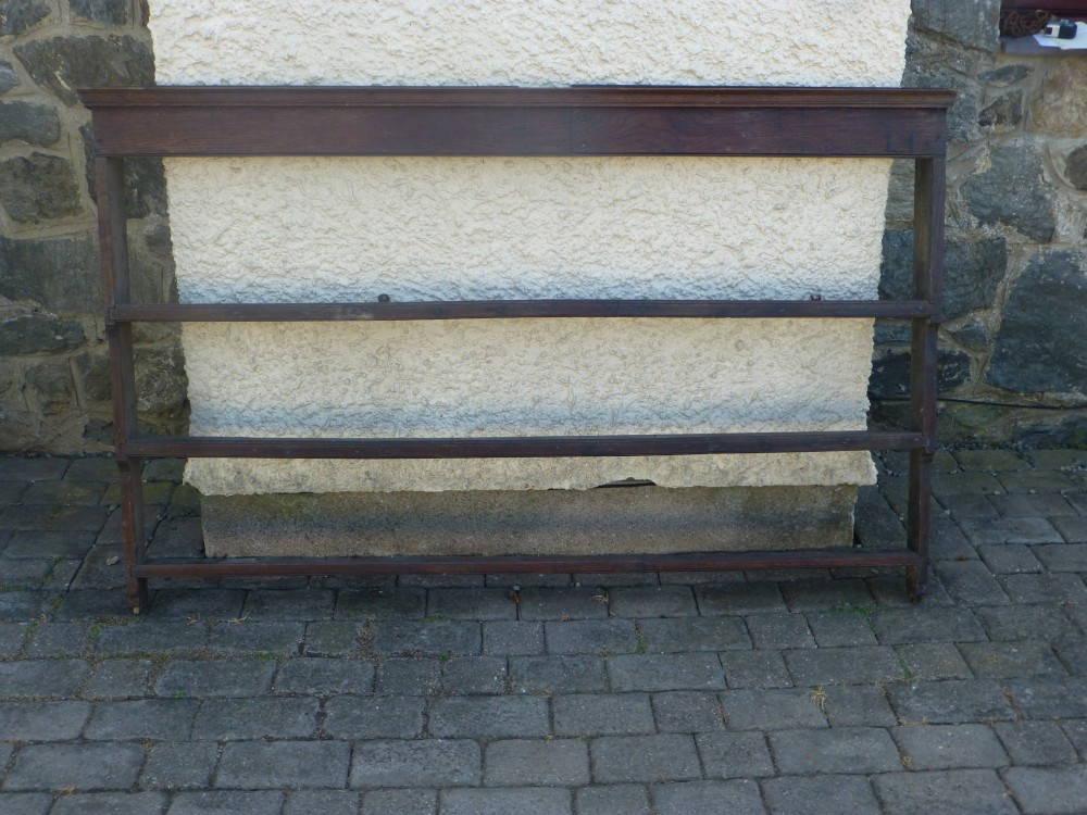 An 18th-century dark oak delft dresser plate rack with a moulded top cornice and three open horizontal display shelves.