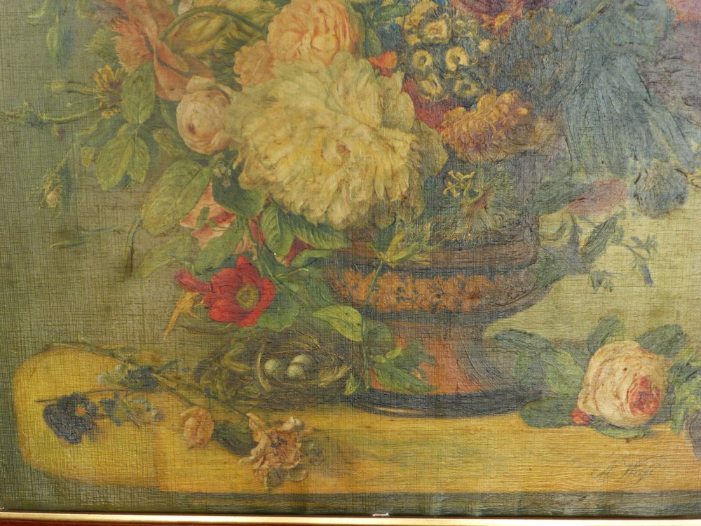 A framed floral still life oleograph print depicting a colourful bouquet of flowers in a stone urn, encased in a wide burgundy frame with gold accents. View II