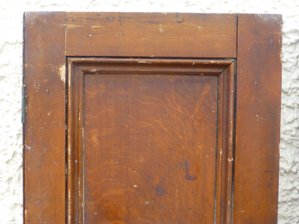 A pair of tall, narrow antique pine cupboard doors featuring a two-panel design and a warm brown scumbled faux oak paint finish. View III