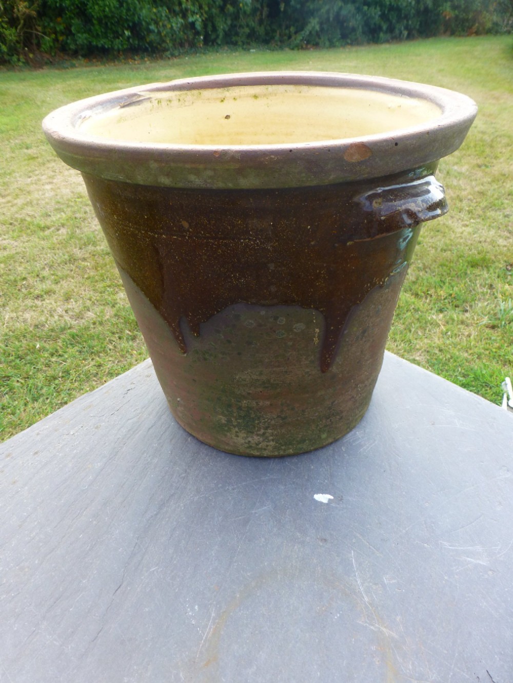 A large 19th-century glazed terracotta dairy salting crock with a wide rolled rim and side handles.