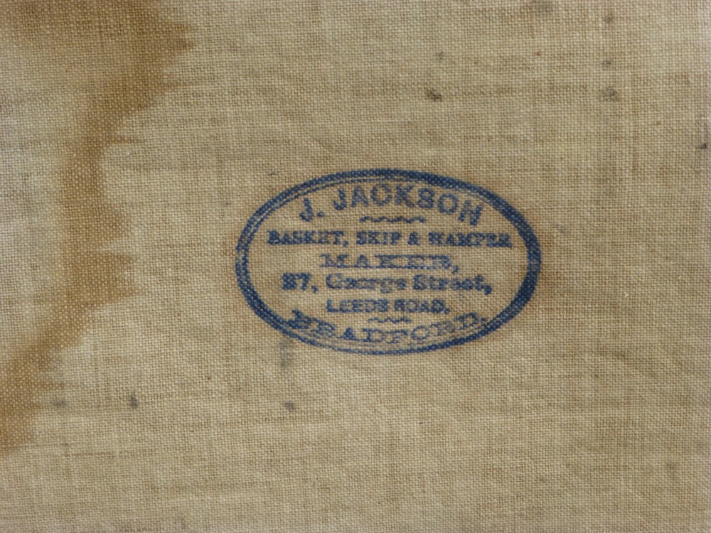 A large 19th-century woven brown wicker travelling trunk with iron latches and stencilled black lettering on the front. View IV