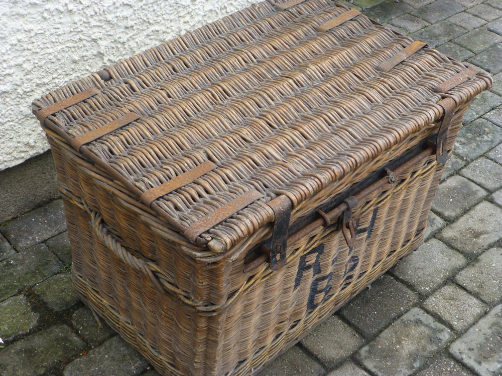A large 19th-century woven brown wicker travelling trunk with iron latches and stencilled black lettering on the front. View V