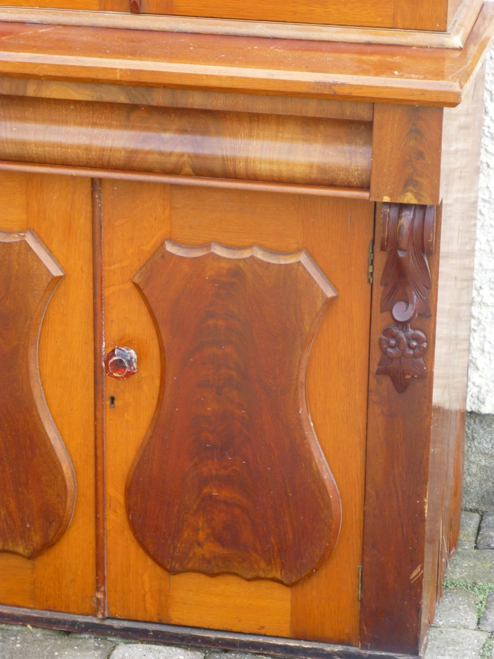 A two-part antique oak and mahogany dresser featuring a triple glazed upper display section above a lower cupboard with carved shaped door panels. View V