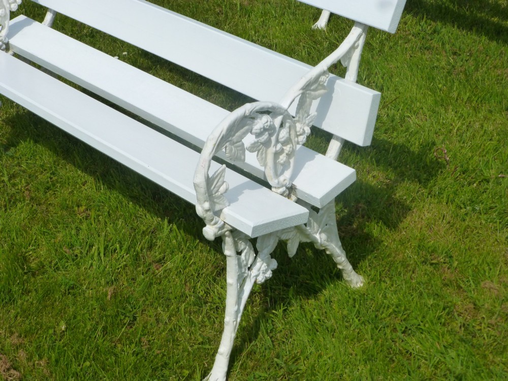 A set of four white painted Victorian garden benches with cast iron end frames in a blackberry and leaf pattern and wooden slatted seats. View VIII