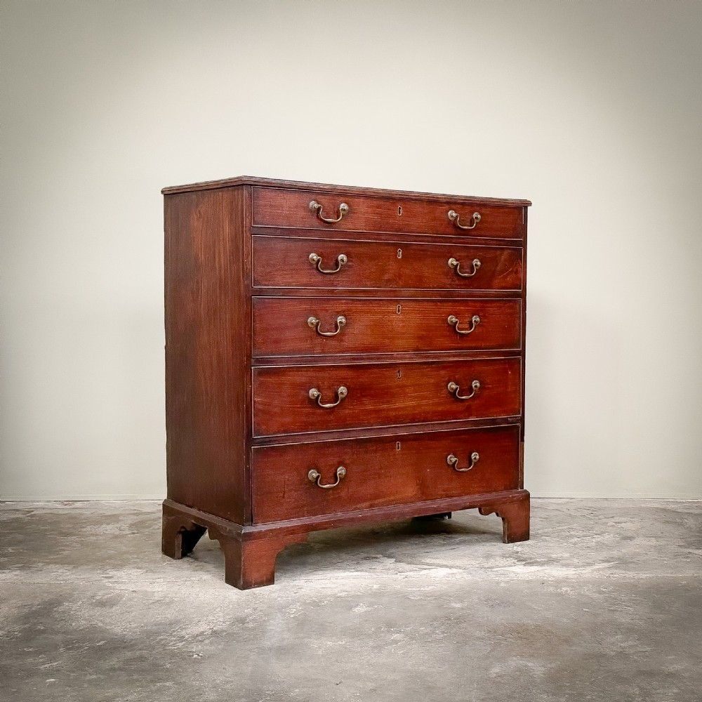 A George III mahogany chest of drawers featuring five graduated drawers with brass swan-neck handles, resting on bracket feet. View III