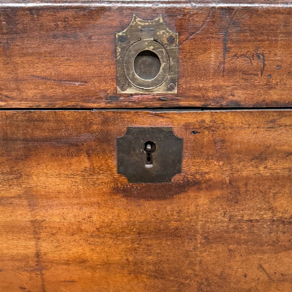 A rectangular warm brown camphor wood trunk featuring flush brass corner brackets, strap mounts, and a central brass keyhole escutcheon. View VI