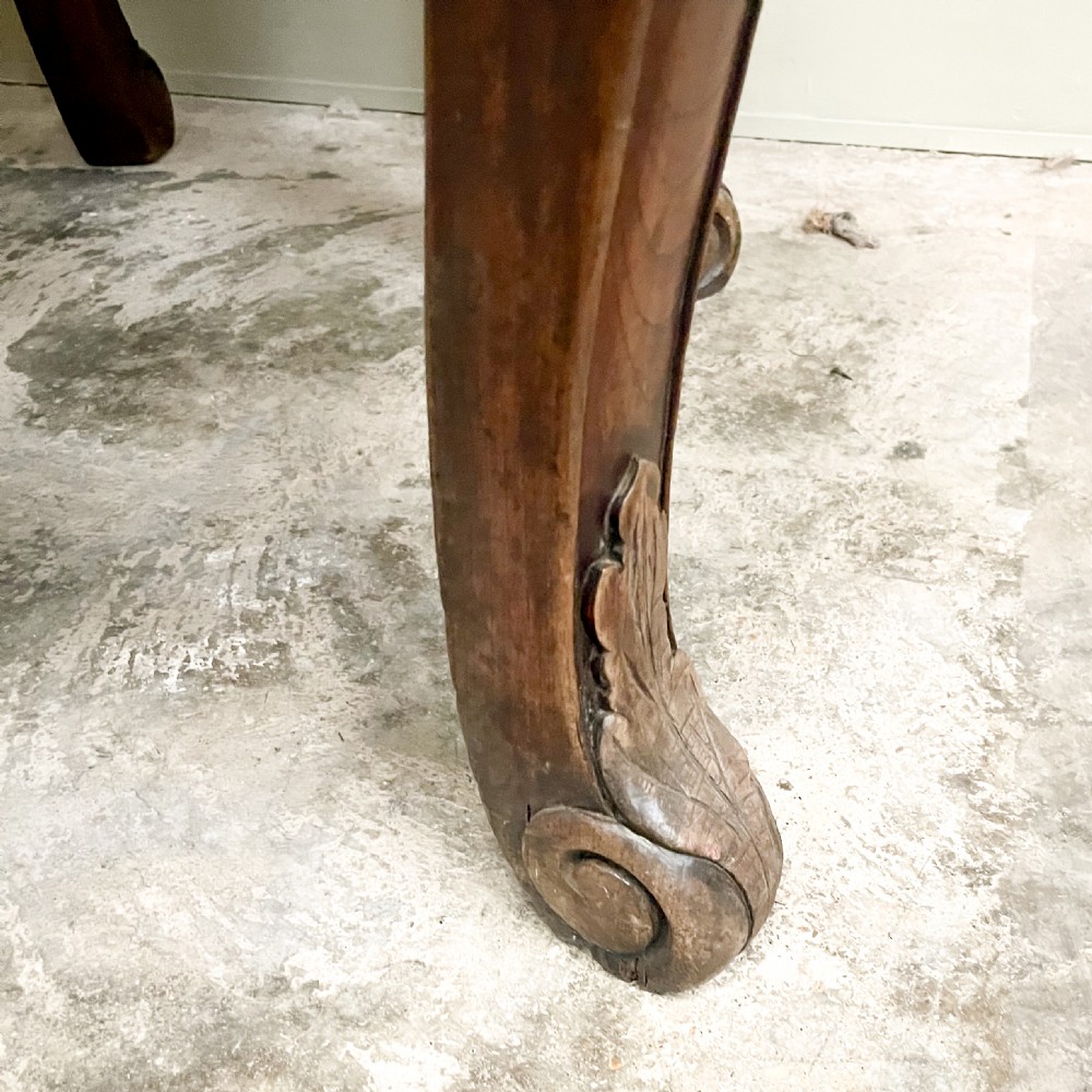 A pair of warm brown semicircular wooden console tables with carved aprons and outward-curved cabriole legs. View VI