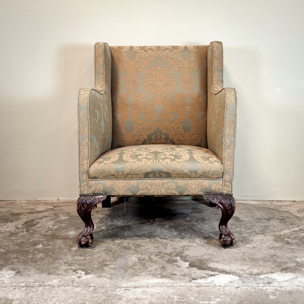 A 19th-century wingback armchair upholstered in patterned sage green damask fabric with carved dark mahogany cabriole legs and ball-and-claw feet. View IV