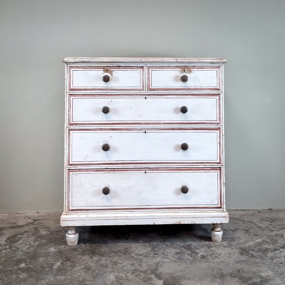 A 19th-century painted pine chest of drawers featuring five drawers with dark turned wooden knobs and red painted line details on an off-white background.
