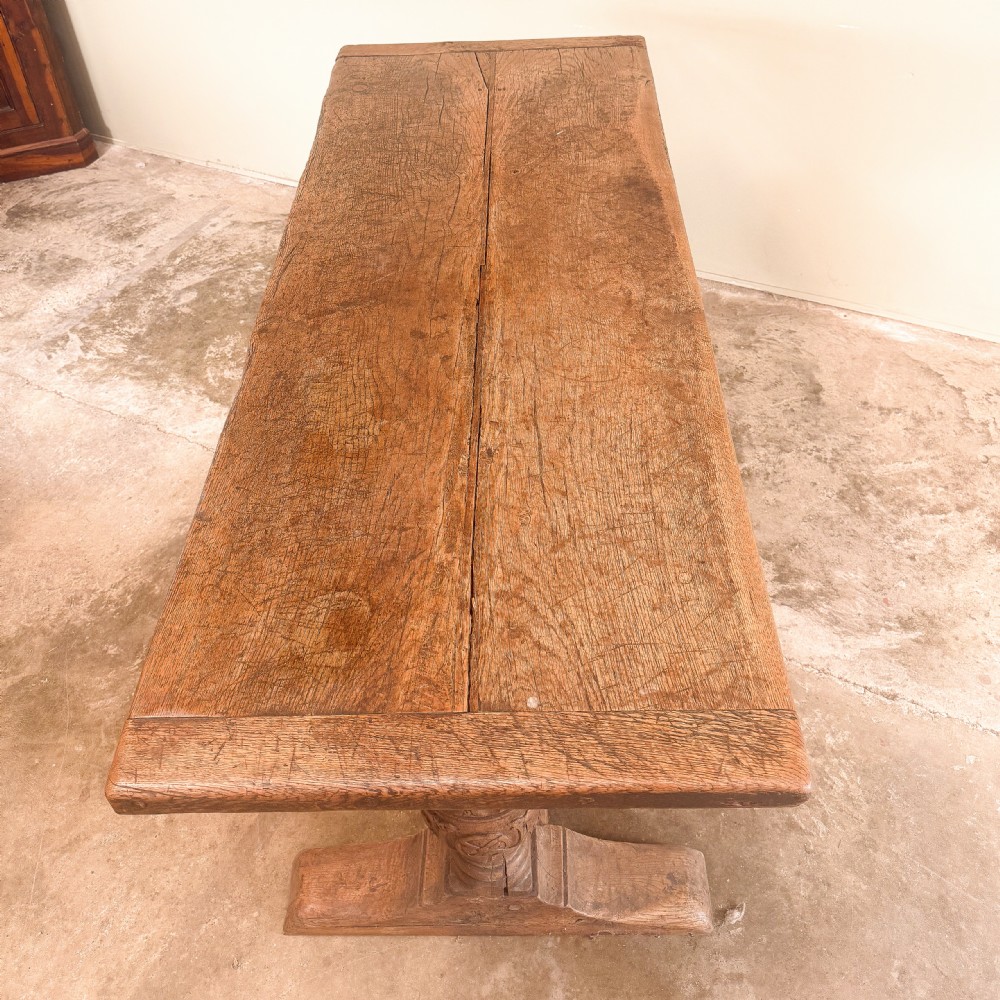 A seventeenth-century oak console table featuring heavily carved cup-and-cover supports and a stretcher base against a neutral wall. View V