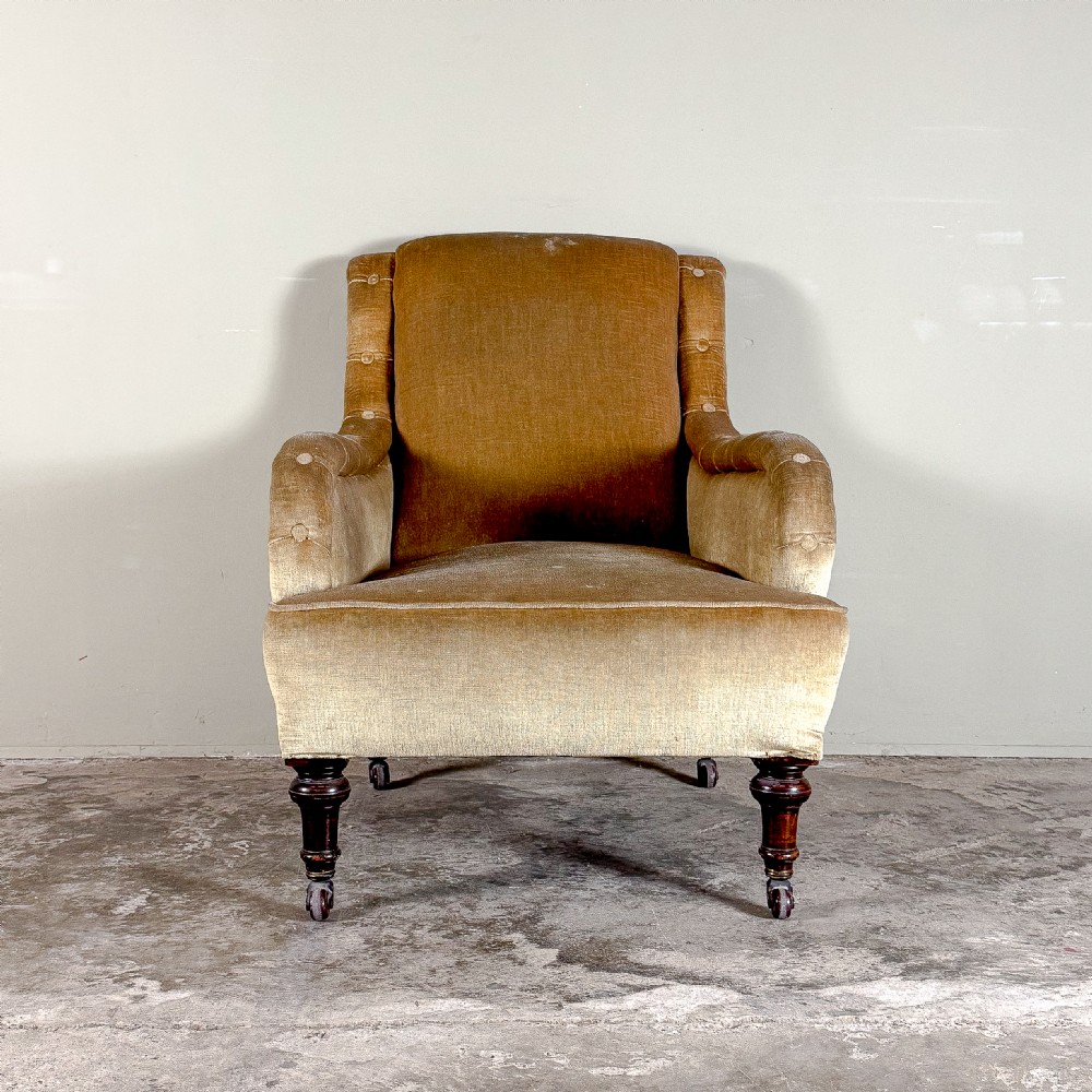A 19th-century Victorian armchair upholstered in ochre gold velvet, featuring rounded P-shaped padded arms and turned dark mahogany front legs with brass castors. View III