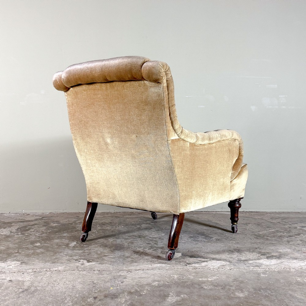 A 19th-century Victorian armchair upholstered in ochre gold velvet, featuring rounded P-shaped padded arms and turned dark mahogany front legs with brass castors. View IV