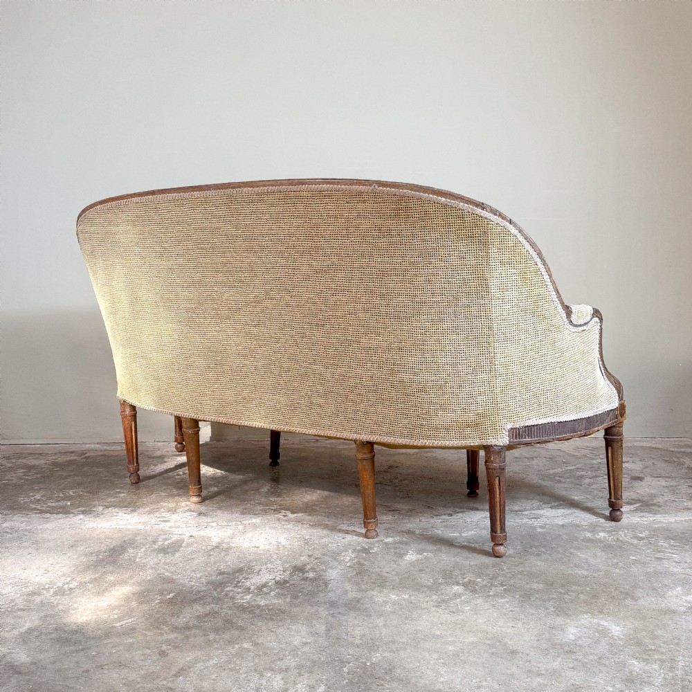 A mid-19th century French canape featuring a carved wooden frame with fluted legs and warm beige upholstery. View VII
