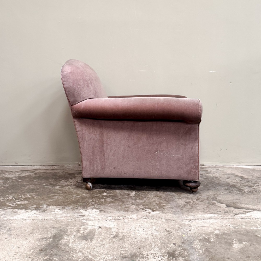 A 1930s upholstered armchair covered in dusty pink velvet with a curved back, rolled arms, and turned feet on castors. View III
