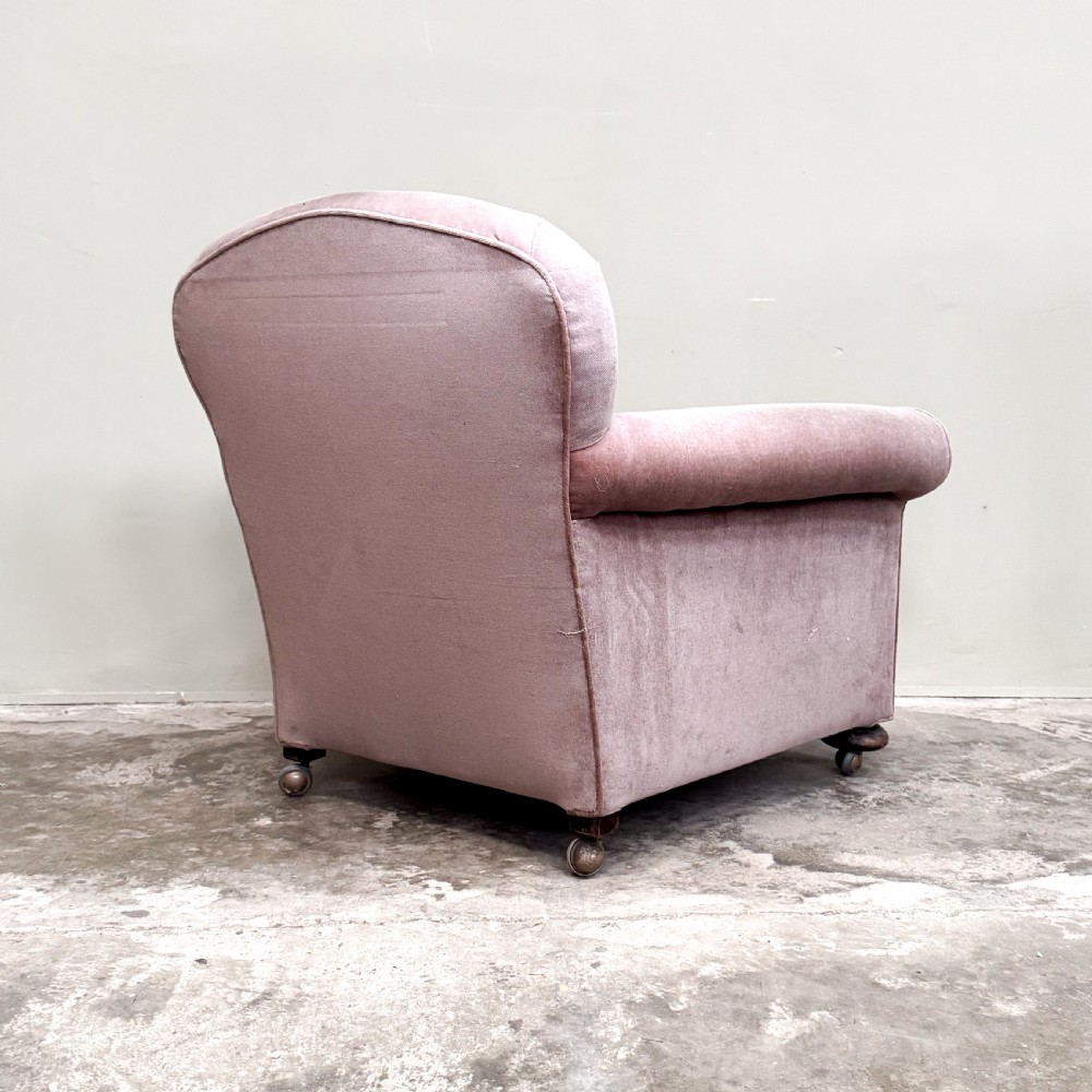 A 1930s upholstered armchair covered in dusty pink velvet with a curved back, rolled arms, and turned feet on castors. View IV