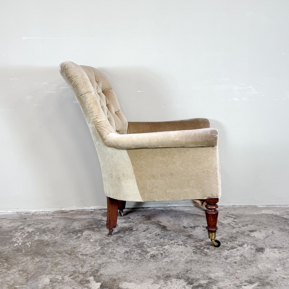 A nineteenth-century Victorian library armchair upholstered in beige velvet featuring a button-tufted backrest and turned mahogany legs with brass castors. View III