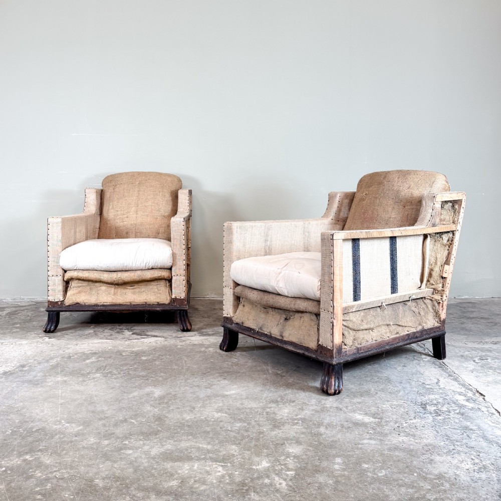A pair of 1920s French armchairs upholstered in beige hessian with white seat cushions, stud trim, and carved dark wooden legs. View II