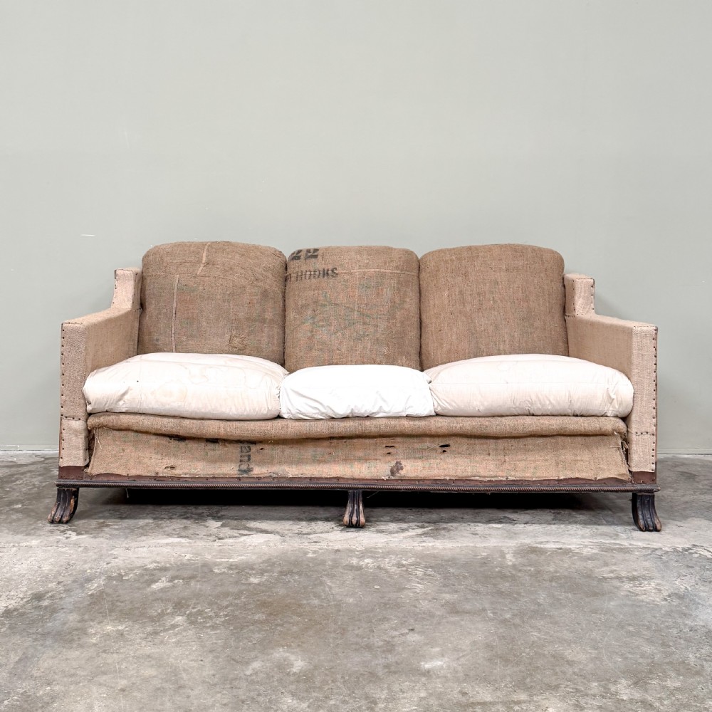 A French three-seater sofa featuring exposed timber framing, natural hessian sacking upholstery, hand-tacked trim, and turned front legs. View II