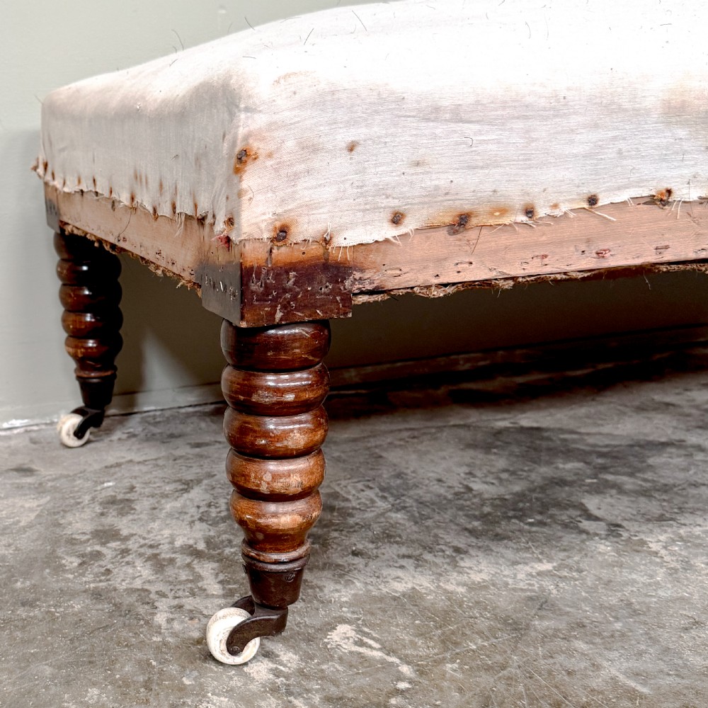 A 19th-century Victorian bobbin day bed featuring a single upholstered arm, button-tufted backrest, dark bobbin-turned legs, and castors. View II