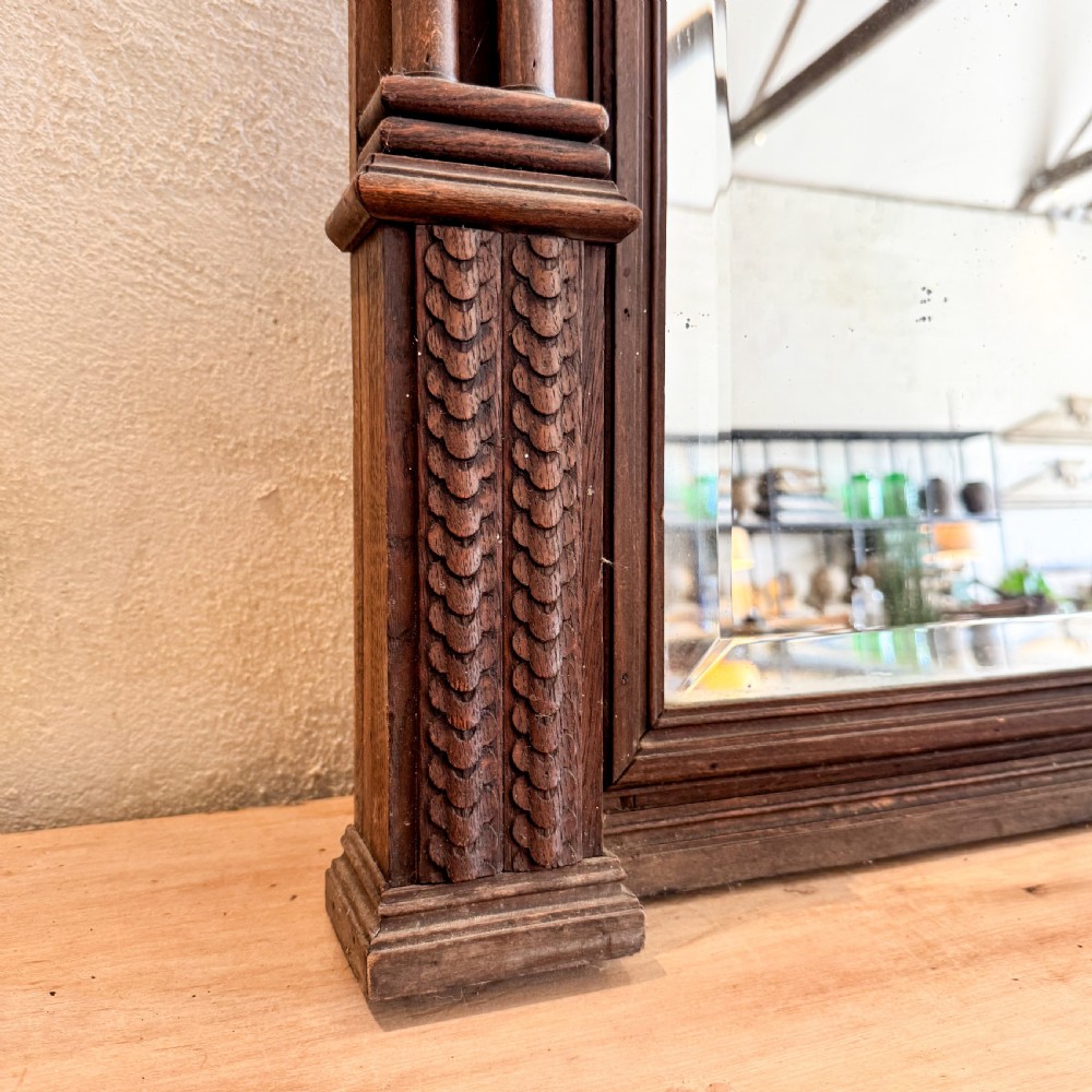 A tall Victorian carved walnut overmantel mirror featuring an architectural cornice, fluted side columns, and an embellished upper frieze. View II