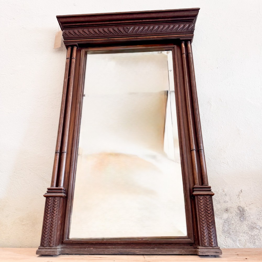 A tall Victorian carved walnut overmantel mirror featuring an architectural cornice, fluted side columns, and an embellished upper frieze. View IV