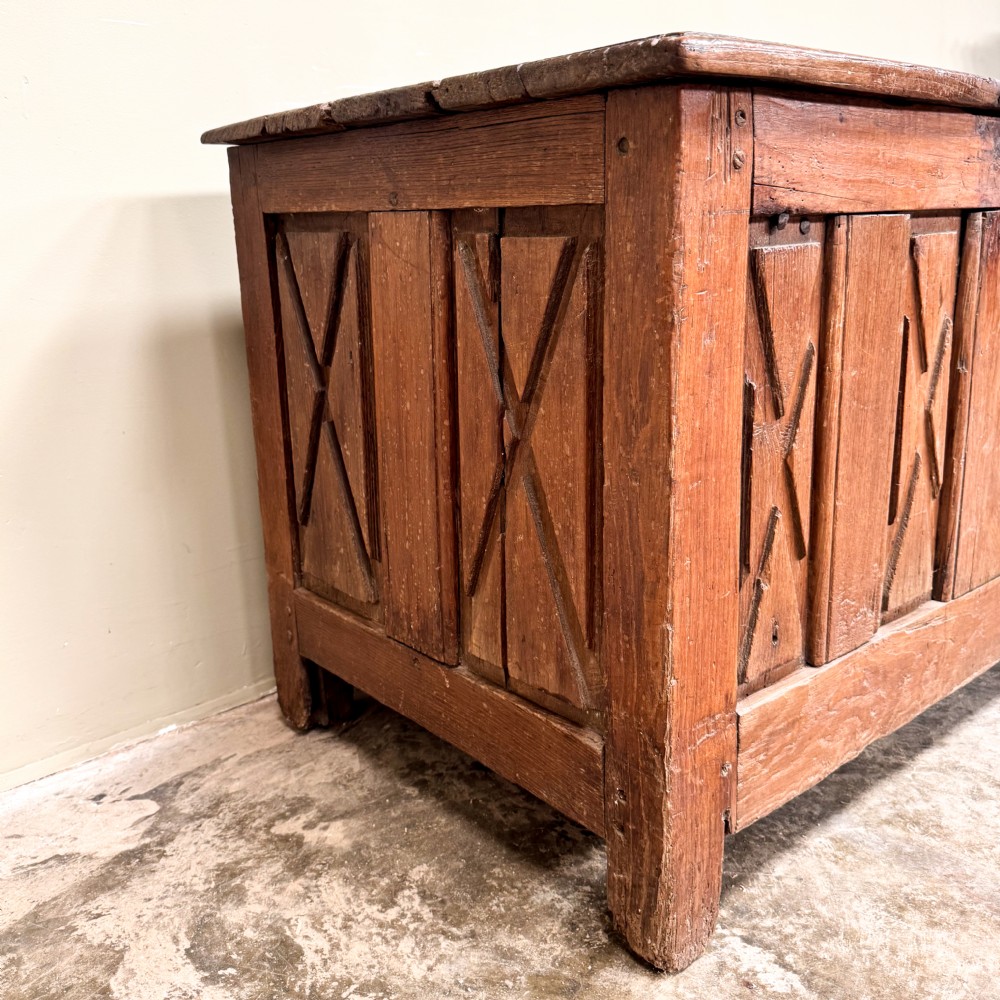 An 18th-century French provincial wooden coffer featuring hand-carved geometric front panels and a hinged top lid. View III