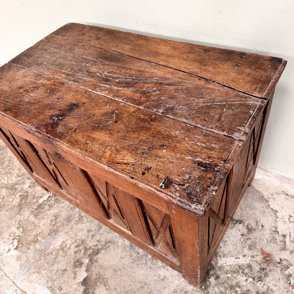 An 18th-century French provincial wooden coffer featuring hand-carved geometric front panels and a hinged top lid. View IV