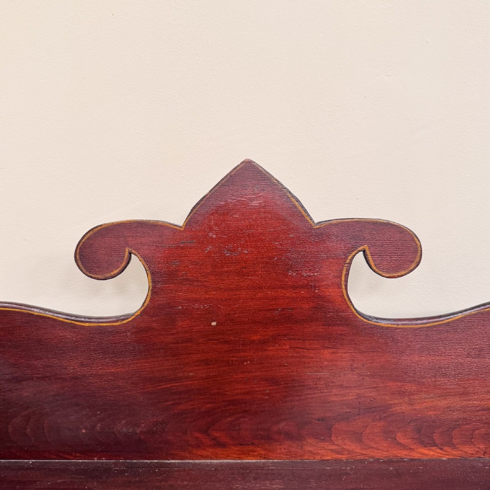 An antique dark reddish-brown painted wooden open bookcase featuring a shaped pediment backboard, a single top drawer with wooden knobs, and four open shelves on turned bun feet. View VI