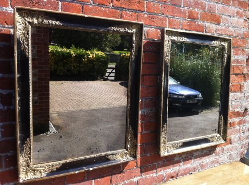 Pair of French Early 19th Century Distressed Black and Gilt Mirrors.