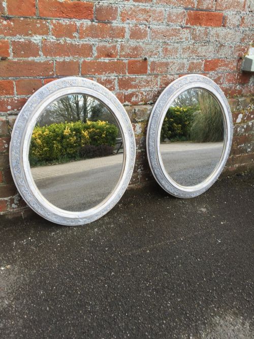 A Pair of Antique 19th Century French Carved Wood & Gesso Distressed Painted and Silvered Oval Mirrors.