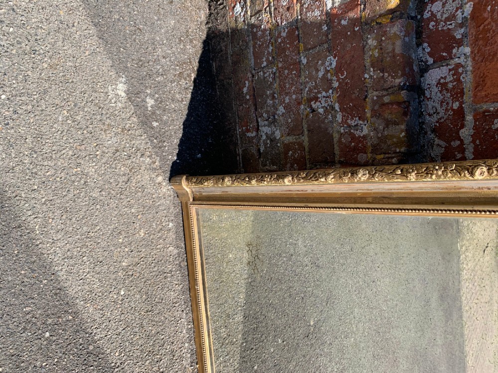 A tall 19th-century French rectangular silvergilt mirror featuring a carved pediment crest, decorative urn finials, and beaded inner frame moulding. View III