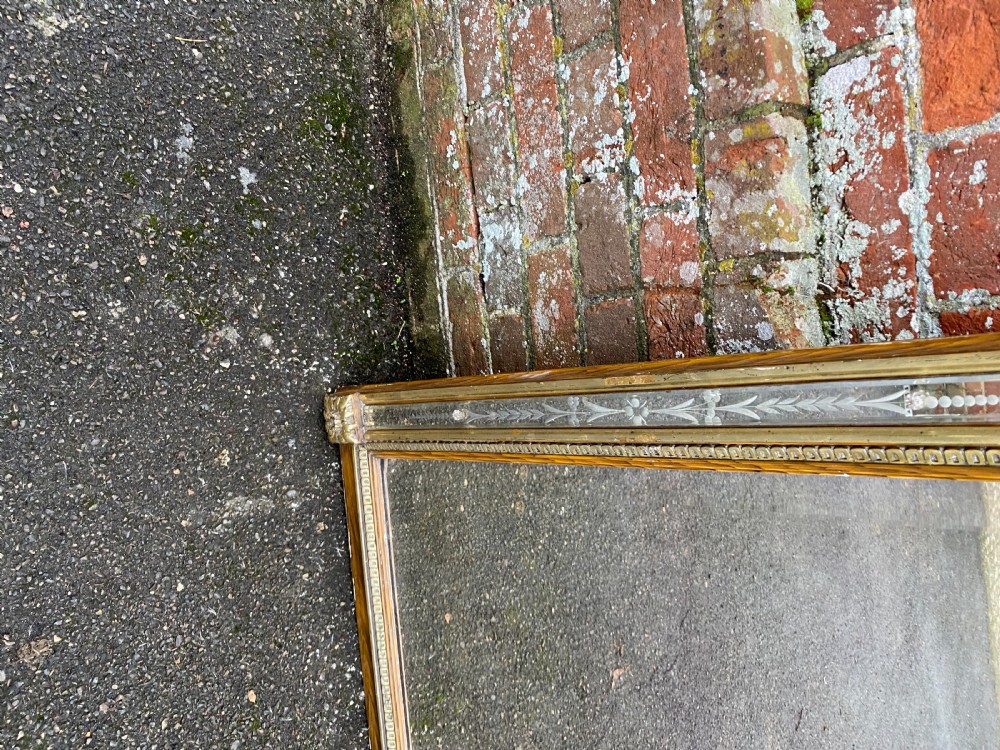 A 19th-century French rectangular wall mirror featuring a carved cherub cresting, urn finials, a gilded beaded frame, and etched glass border panels. View IV