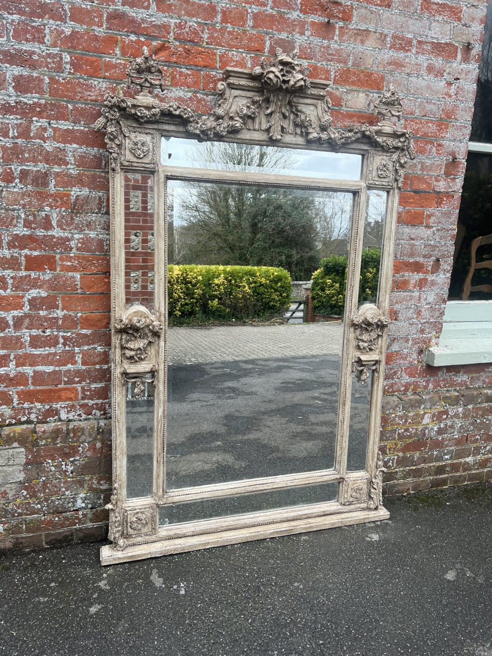 A large early 20th-century French cushion mirror featuring a carved off-white gesso frame, ornate crest, and marginal glass border panels. View IX