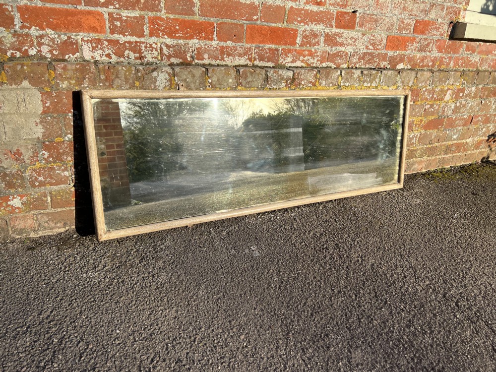 A tall and narrow 19th-century French bistro mirror featuring a slender carved wood and painted gesso frame with patinated mirror glass. View III