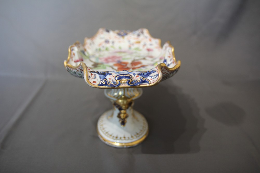 An antique Masons ironstone footed comport featuring floral patterns, a scalloped rim, and gilded detailing on a pedestal base. View III
