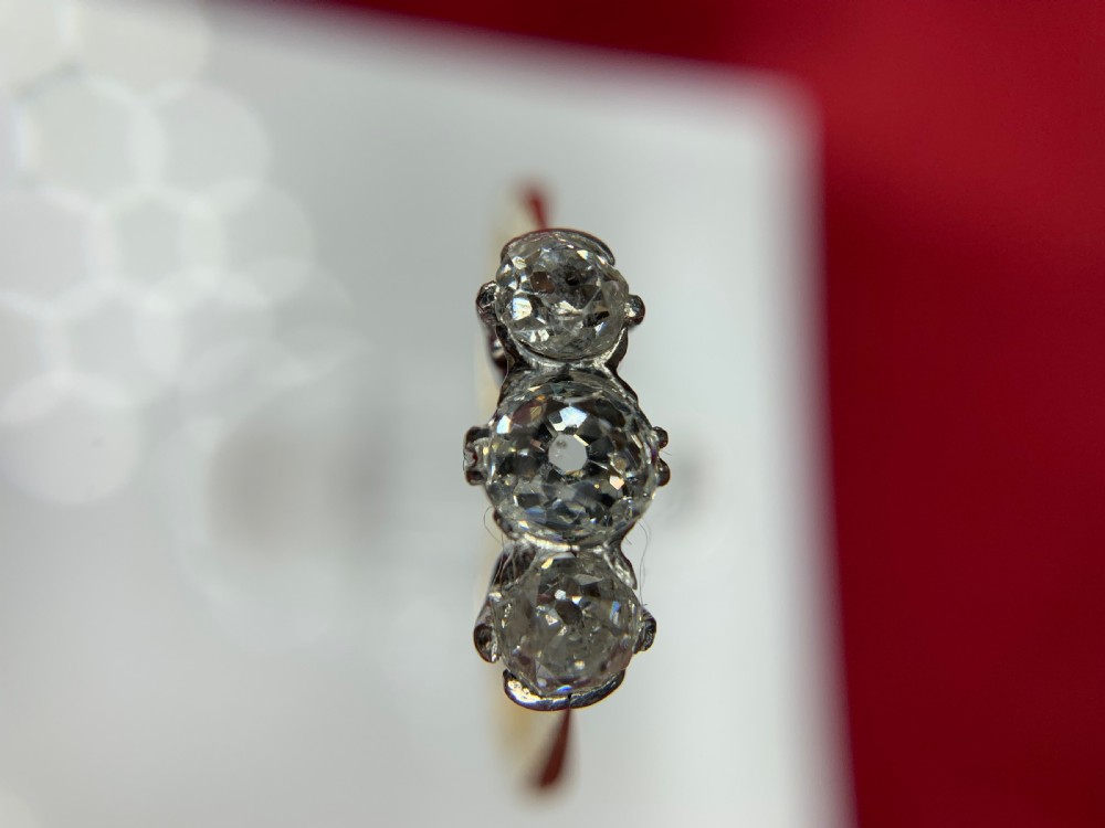 An 18ct yellow gold trilogy ring set with three round old-cut diamonds in a claw setting. View IX