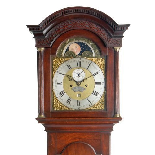 fig 1. An antique Georgian mahogany longcase clock featuring an arched hood with fluted columns and a brass dial with an integrated moonphase display.
