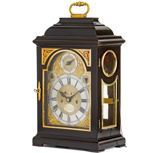 fig 1. An 18th-century Georgian ebonised table clock featuring a bell top case, brass handle, and silvered chapter ring dial.