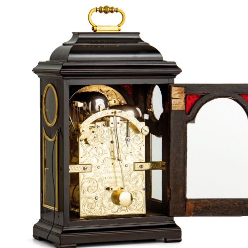 fig 2. An 18th-century Georgian ebonised table clock featuring a bell top case, brass handle, and silvered chapter ring dial.