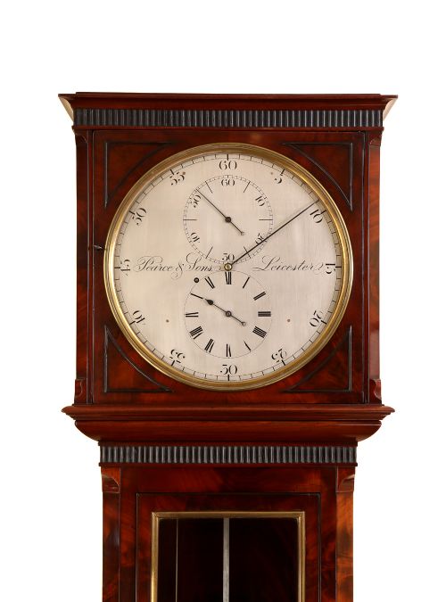fig 1. An English flame mahogany longcase regulator clock with a silvered dial signed by Pearce and Sons Leicester, featuring a glass glazed trunk displaying a mercury pendulum.