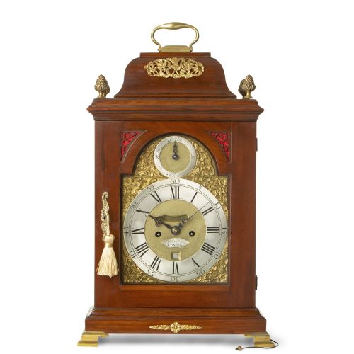 fig 1. A Georgian mahogany bracket clock with a brass carrying handle, pinecone finials, and an arched brass dial signed Robert Higgs London.