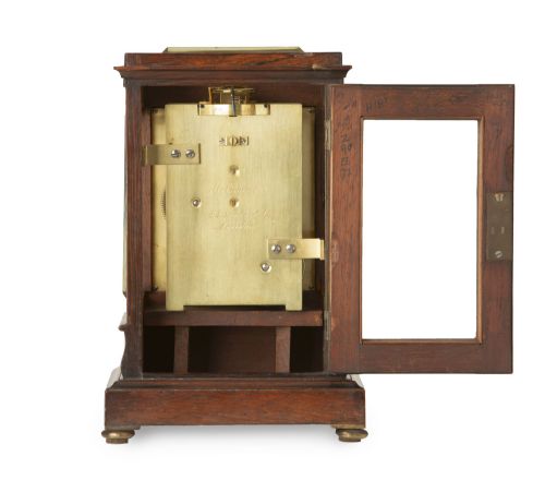 fig 3. An early nineteenth-century rosewood five-glass library timepiece featuring an engine-turned brass dial with Roman numerals and a stepped plinth base.
