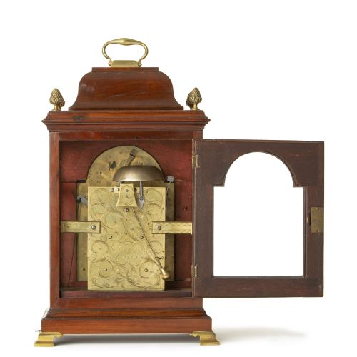 fig 3. A Georgian mahogany bracket clock with a brass carrying handle, pinecone finials, and an arched brass dial signed Robert Higgs London.