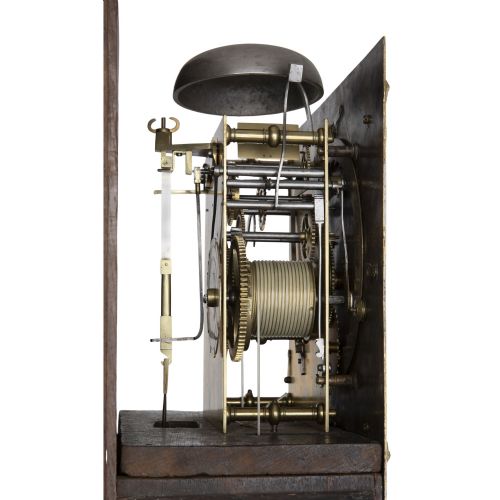 fig 2. A slender late 17th-century walnut longcase clock featuring a square brass dial, barley twist hood columns, and rich figure-grained timber.