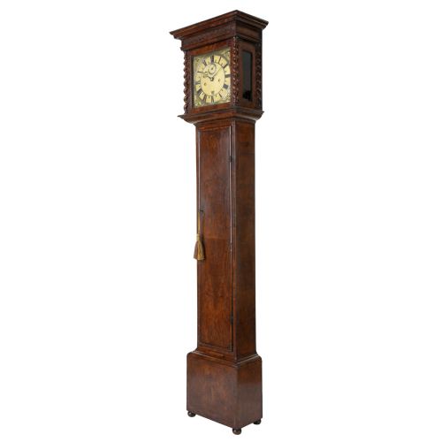 fig 3. A slender late 17th-century walnut longcase clock featuring a square brass dial, barley twist hood columns, and rich figure-grained timber.