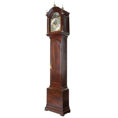 fig 1. A Georgian flame mahogany longcase clock with brass urn finials and an arched brass dial depicting a moving windmill automata scene.