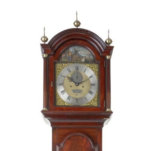 fig 2. A Georgian flame mahogany longcase clock with brass urn finials and an arched brass dial depicting a moving windmill automata scene.